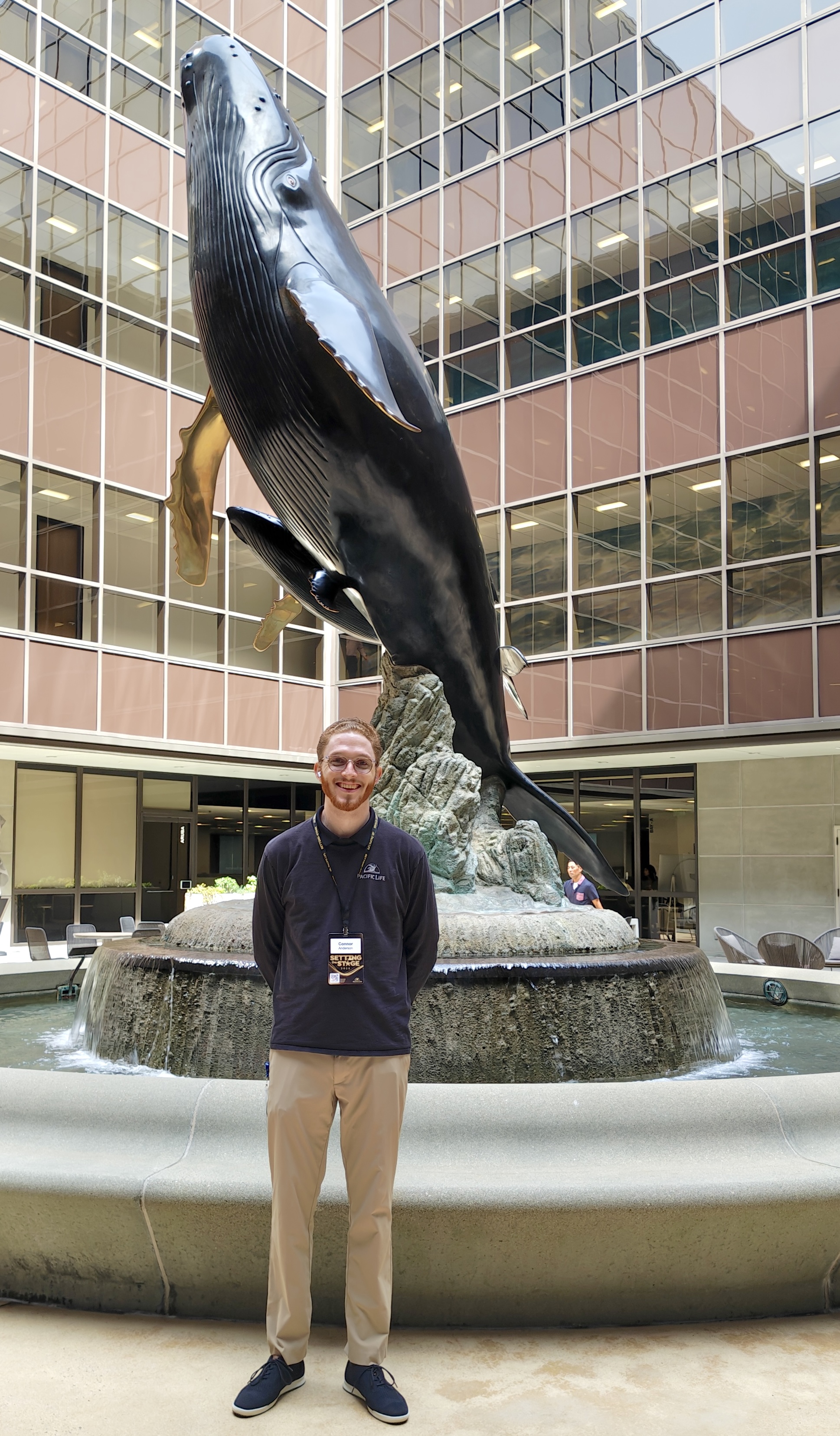 Man standing by humpback whale statue 